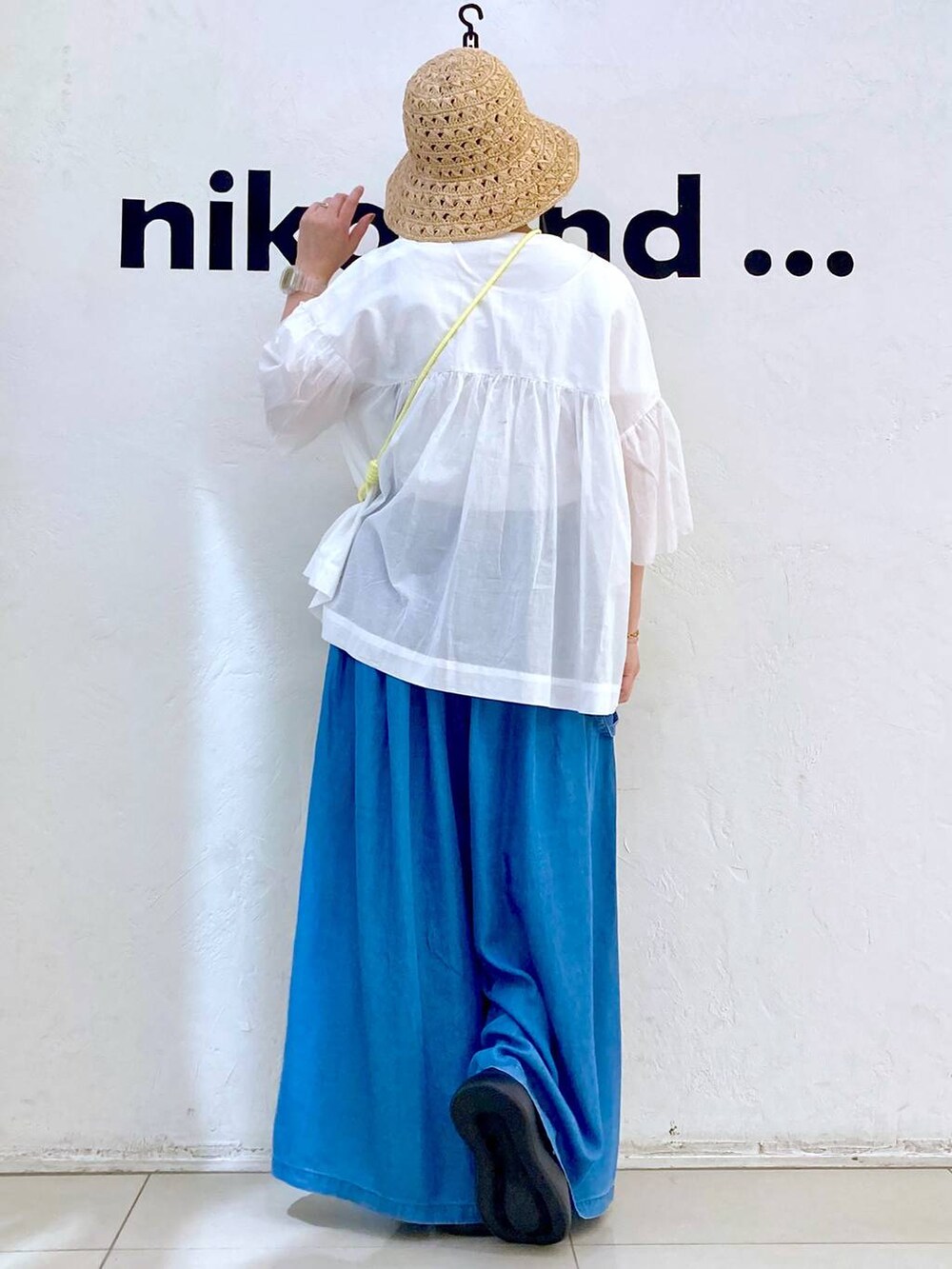 ブルー系のショルダーバッグ、ブラック系のサンダル、ブルー系のデニムパンツを着用したレディースの春コーディネートの4枚目の写真