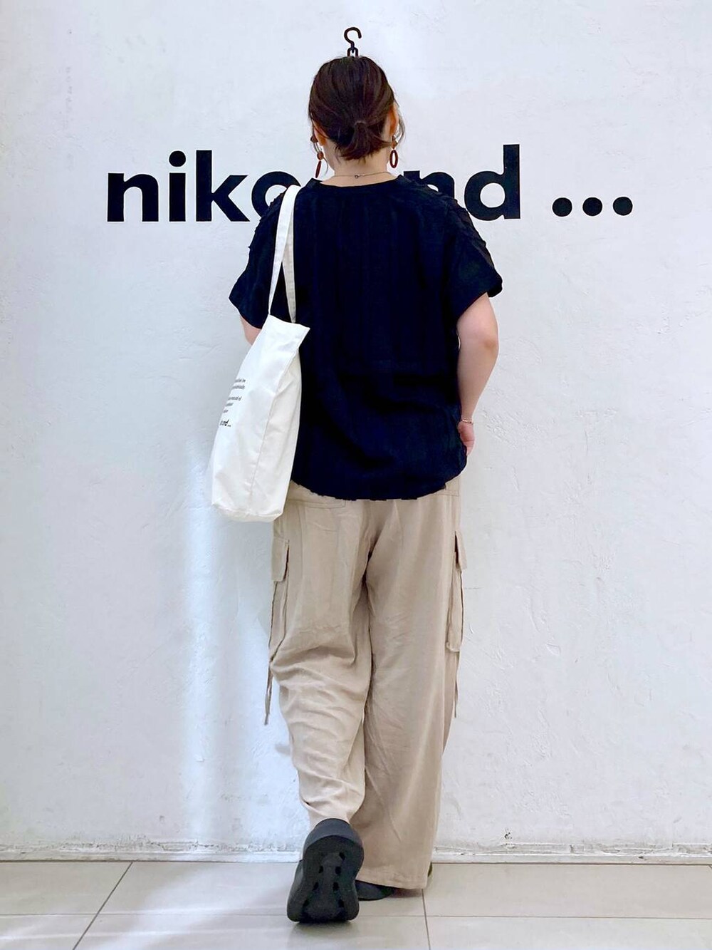 ブラック系のサンダル、ベージュ系のカーゴパンツ、ベージュ系のトートバッグを着用したレディースの夏コーディネートの4枚目の写真