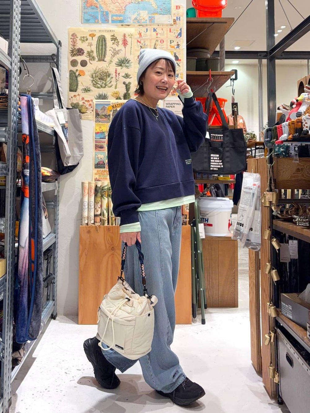 ブルー系のデニムパンツ、ブルー系のスウェット、ベージュ系のショルダーバッグを着用したレディースの冬コーディネートの3枚目の写真