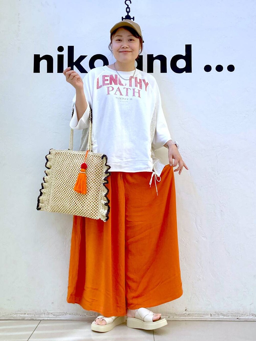 ベージュ系のサンダル、ベージュ系のトートバッグ、ホワイト系のデジタル腕時計を着用したレディースの夏コーディネートの2枚目の写真