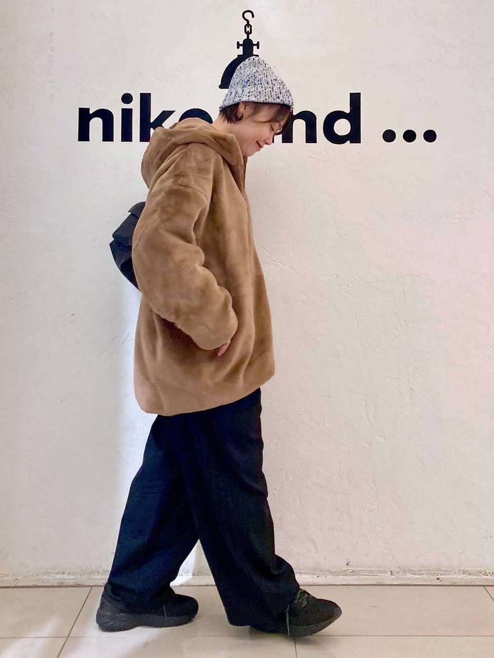 ホワイト系のTシャツ/カットソー、ブルー系のニット/セーター、ブラウン系のブルゾンを着用したレディースの秋コーディネートの4枚目の写真