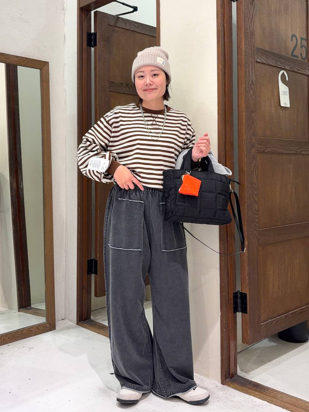 ブラック系のトートバッグ、グレー系のベストを着用したレディースの冬コーディネートの2枚目の写真