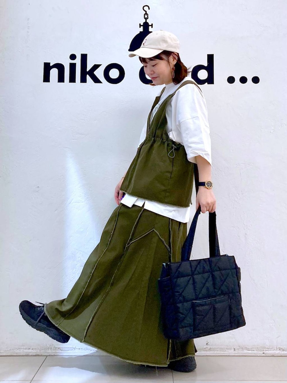 ブラック系のトートバッグ、ホワイト系のTシャツ/カットソー、ゴールド系のブレスレットを着用したレディースの春コーディネートの3枚目の写真