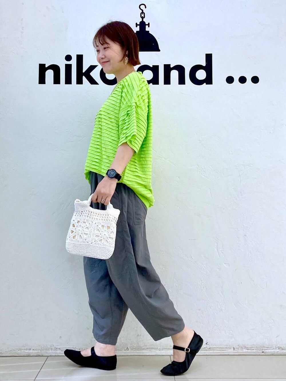 ホワイト系のショルダーバッグ、グリーン系のTシャツ/カットソー、グレー系のその他パンツを着用したレディースの春コーディネートの3枚目の写真