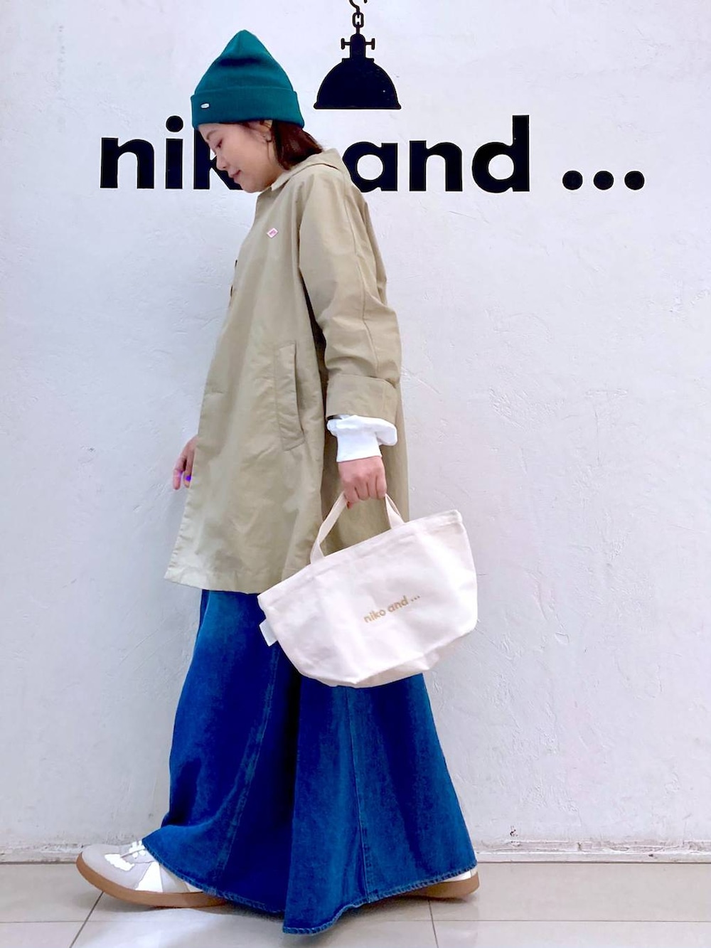 ホワイト系のスニーカー、ホワイト系のトートバッグ、シルバー系のピアス（両耳用）を着用したレディースの春コーディネートの3枚目の写真