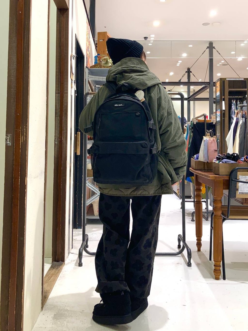 ブラック系のモカシン/デッキシューズ、ブラック系のバックパック/リュック、グレー系のその他パンツを着用したレディースの冬コーディネートの4枚目の写真