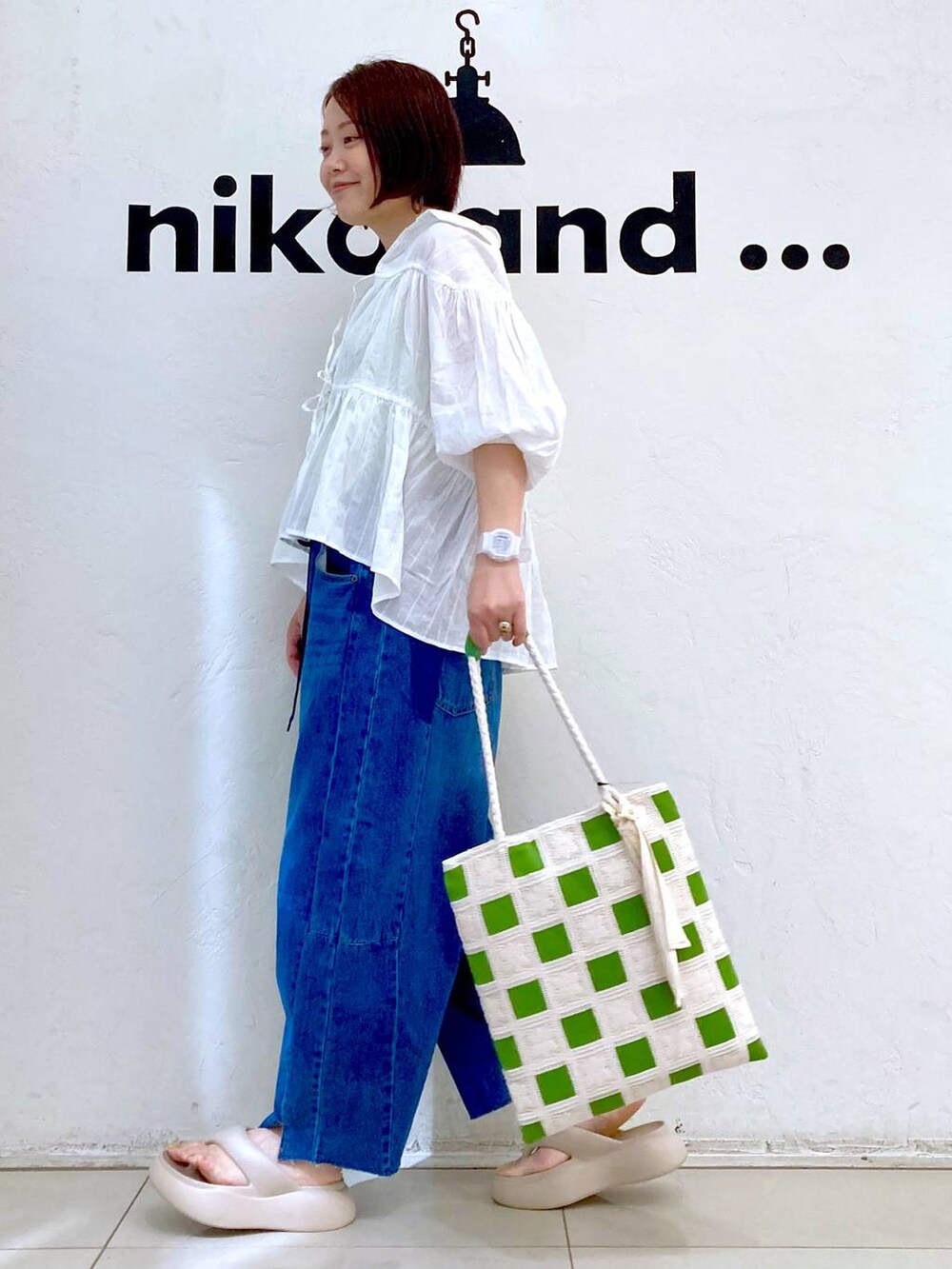 ベージュ系のサンダル、ブルー系のデニムパンツ、グリーン系のタンクトップを着用したレディースの夏コーディネートの5枚目の写真