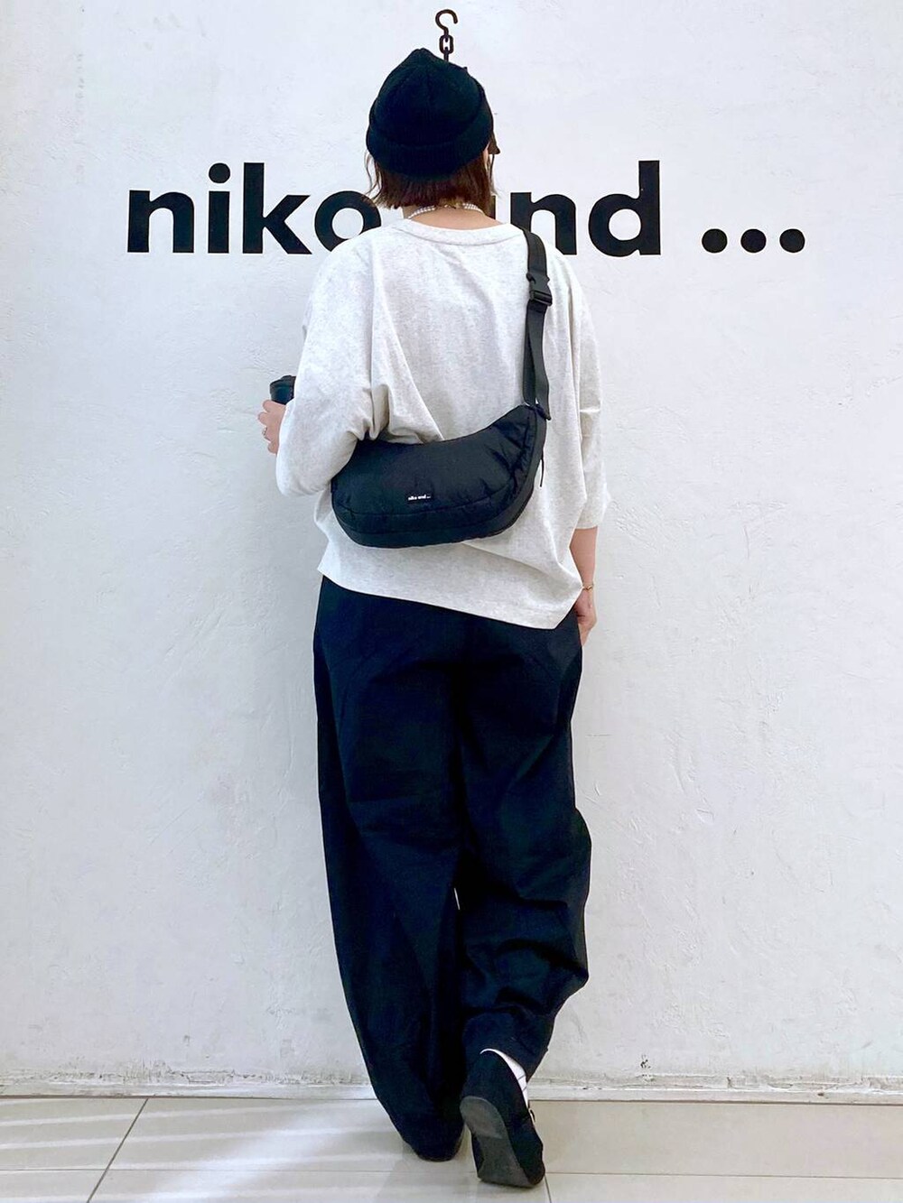 ベージュ系のTシャツ/カットソー、ブラック系のショルダーバッグ、ブラック系のその他パンツを着用したレディースの春コーディネートの4枚目の写真
