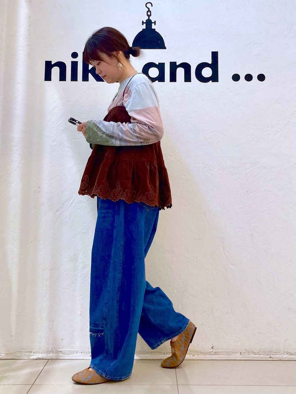 ブラウン系のパンプス、ベージュ系のTシャツ/カットソー、ブルー系のデニムパンツを着用したレディースの夏コーディネートの3枚目の写真