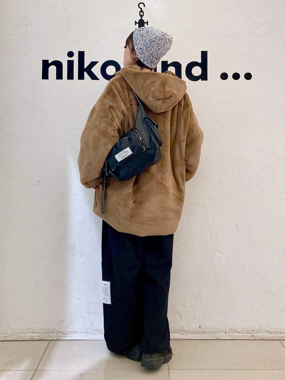 ホワイト系のTシャツ/カットソー、ブルー系のニット/セーター、ブラウン系のブルゾンを着用したレディースの秋コーディネートの5枚目の写真