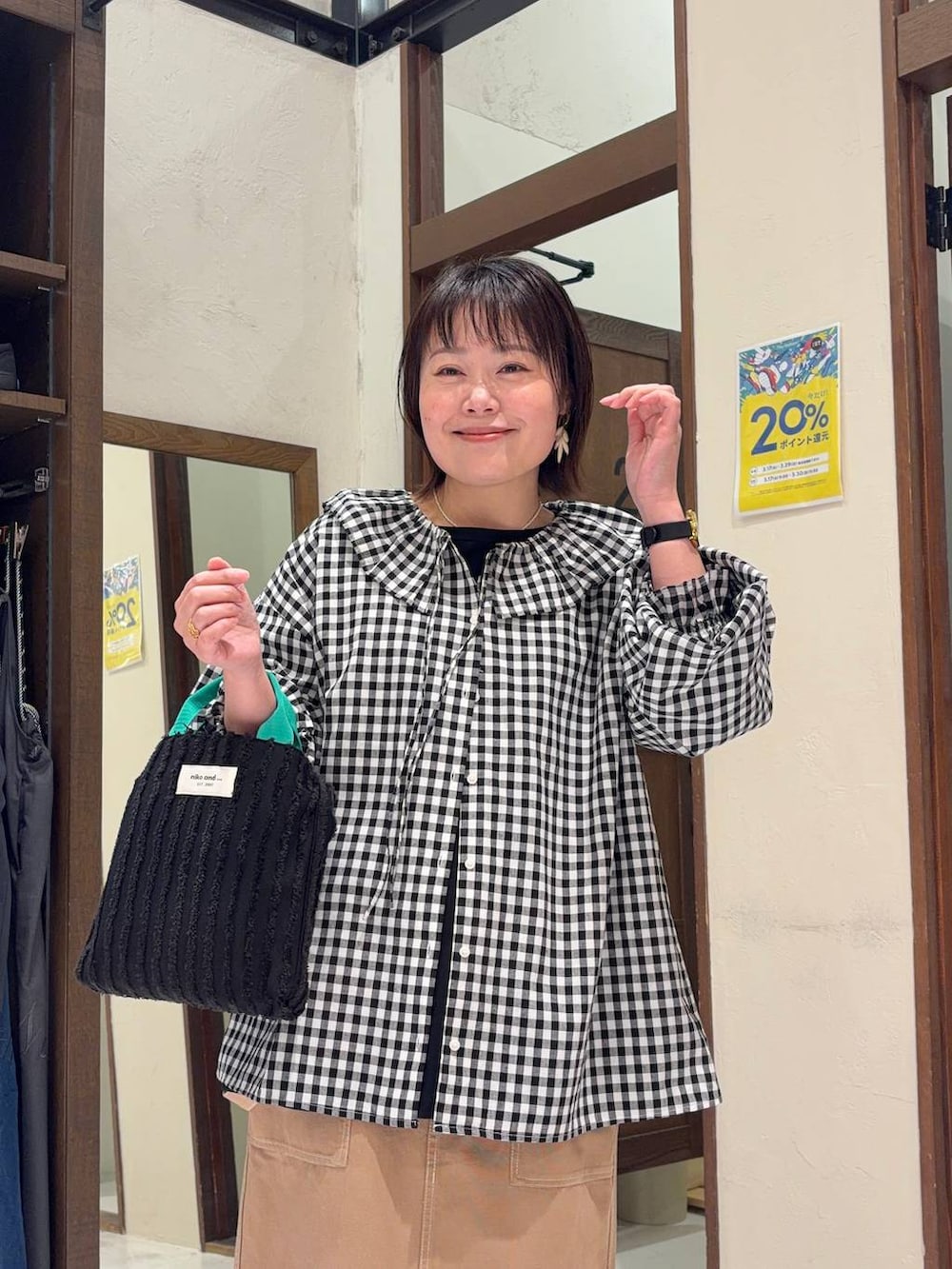 イエロー系のスカート、ブラック系のパンプス、ブラック系のトートバッグを着用したレディースの春コーディネートの6枚目の写真