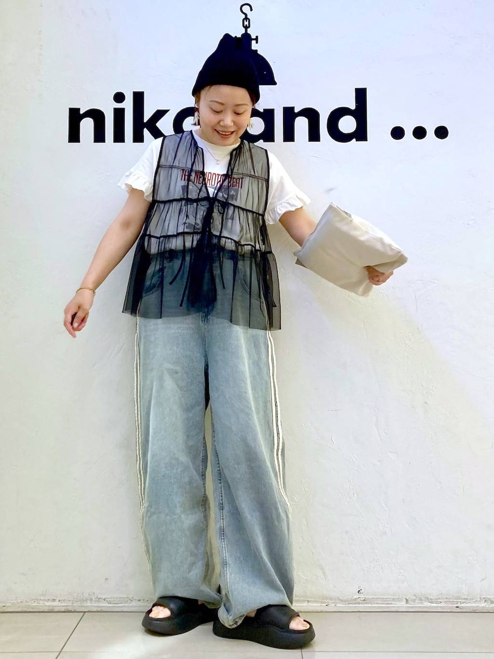 ブラック系のサンダル、ホワイト系のTシャツ/カットソー、ブラック系のベストを着用したレディースの夏コーディネートの2枚目の写真