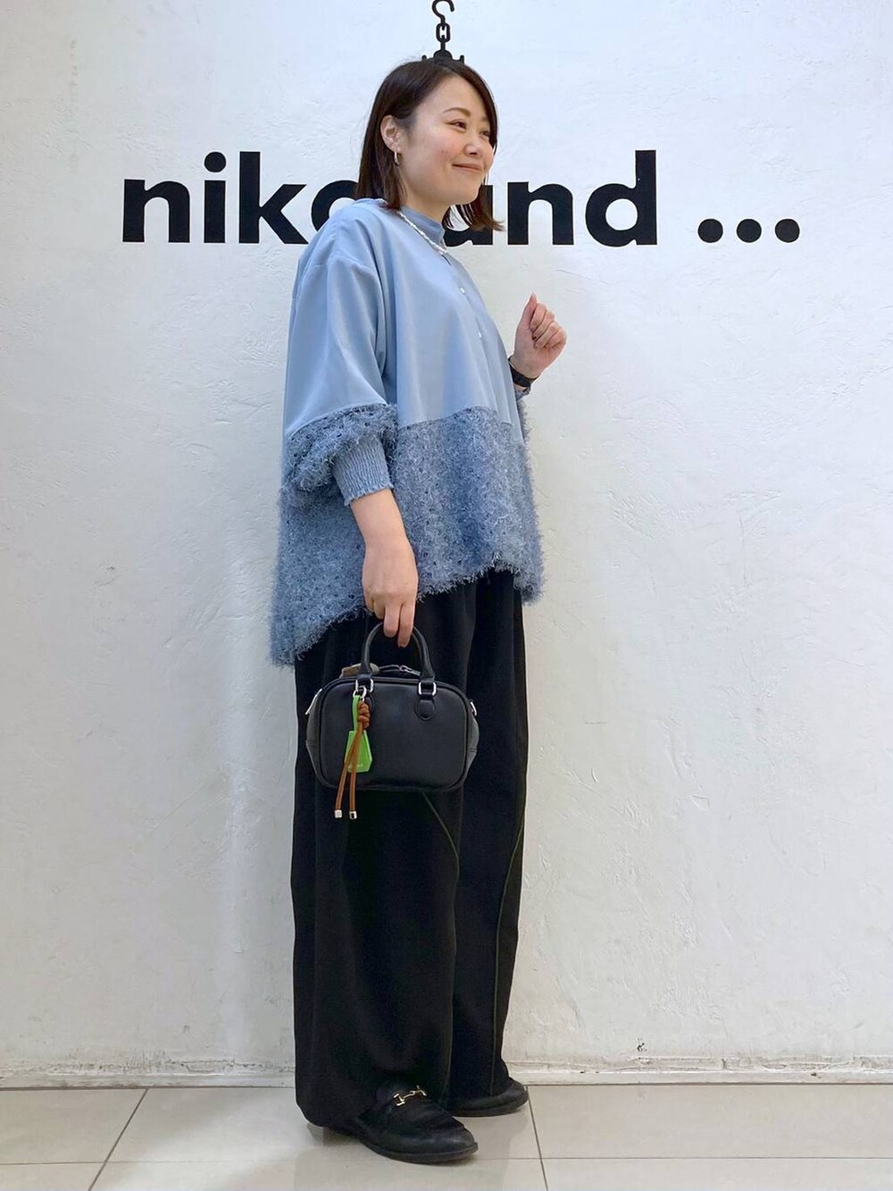 ブラック系のボストンバッグ、ブルー系のシャツ/ブラウス、シルバー系のピアス(両耳用)を着用したレディースの冬コーディネートの5枚目の写真