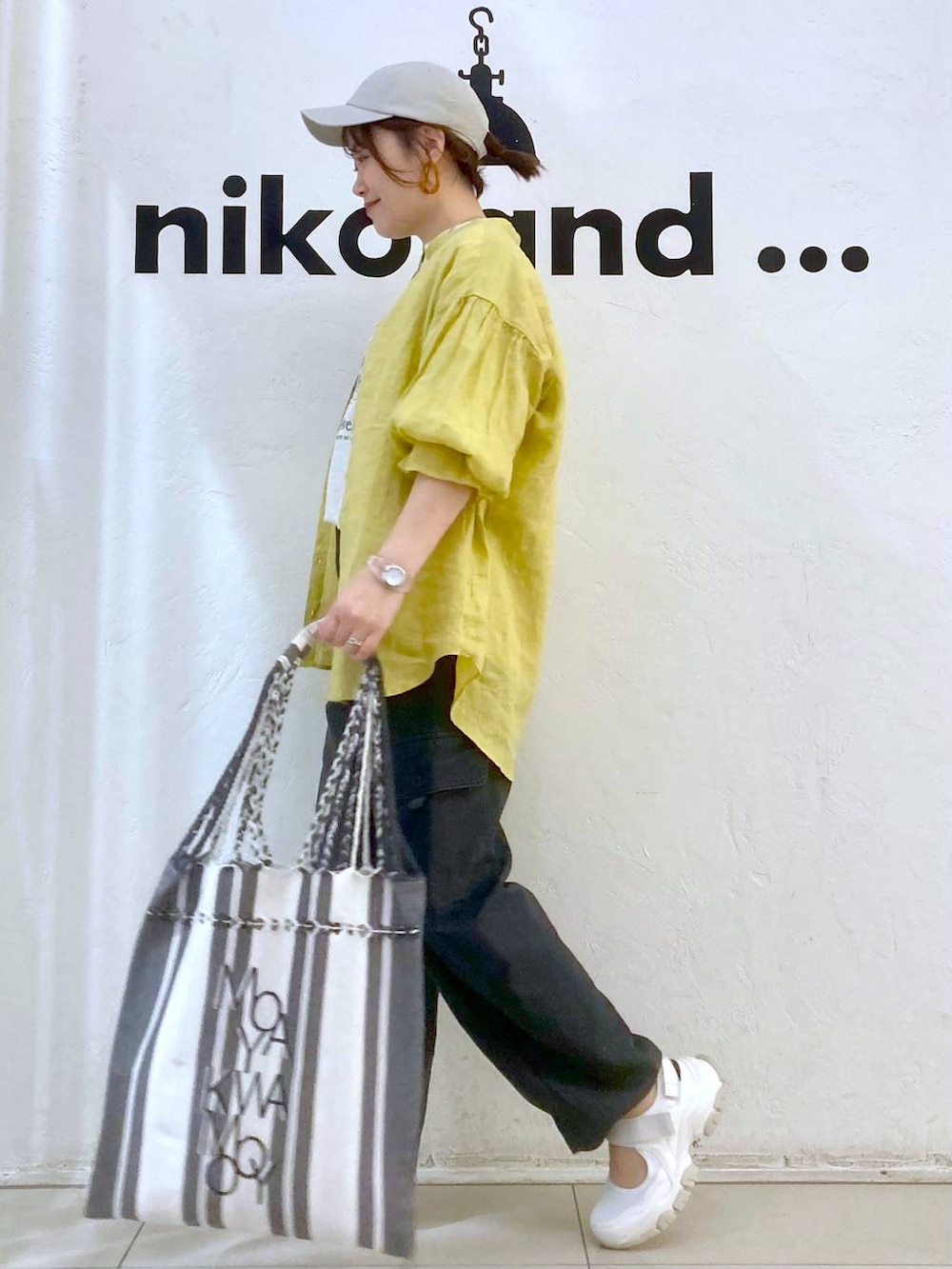 ベージュ系のTシャツ/カットソー、イエロー系のシャツ/ブラウス、グレー系のカーゴパンツを着用したレディースの春コーディネートの5枚目の写真