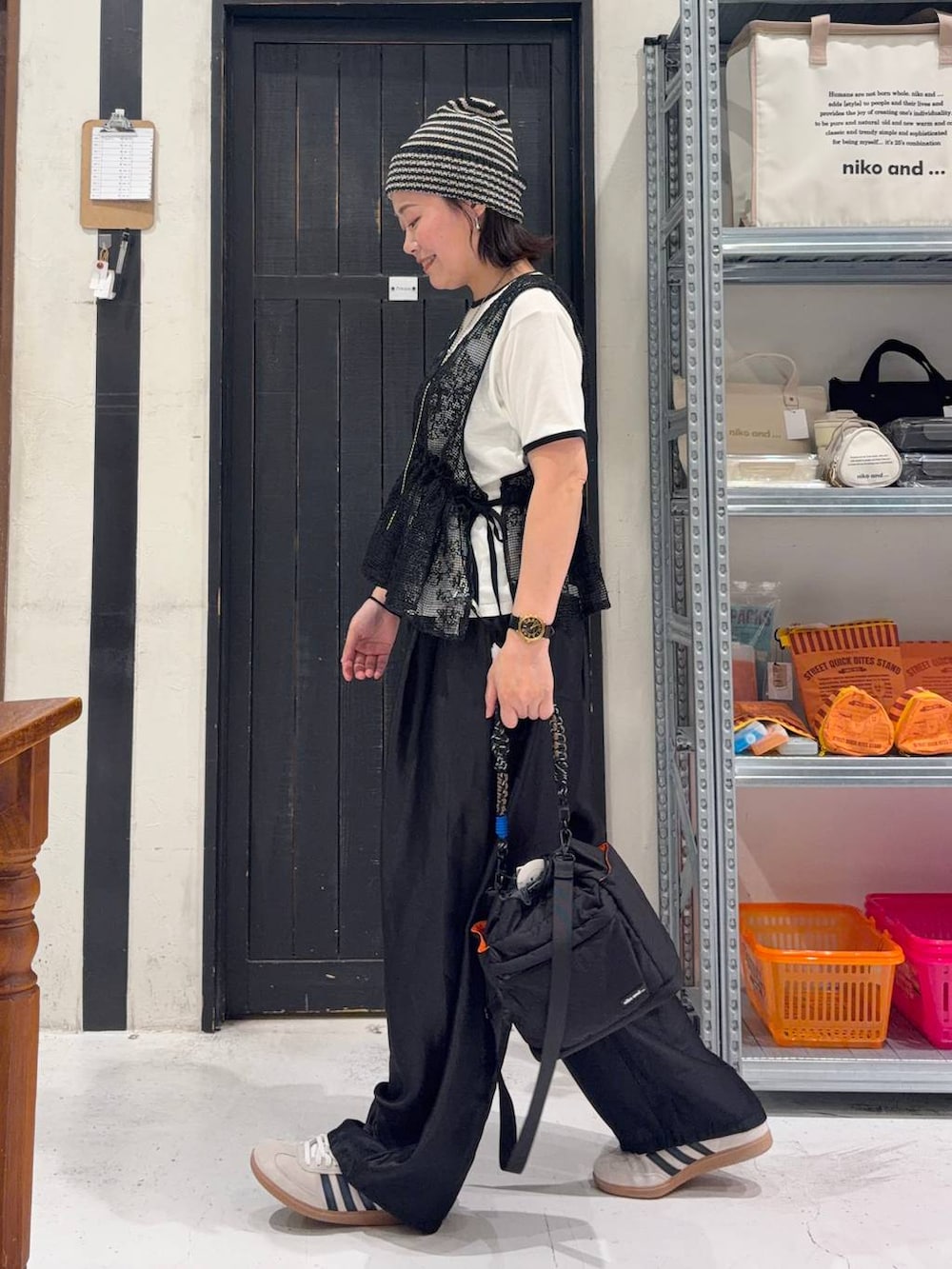 ブラック系のショルダーバッグ、ベージュ系のTシャツ/カットソー、ブラック系のベストを着用したレディースの春コーディネートの3枚目の写真