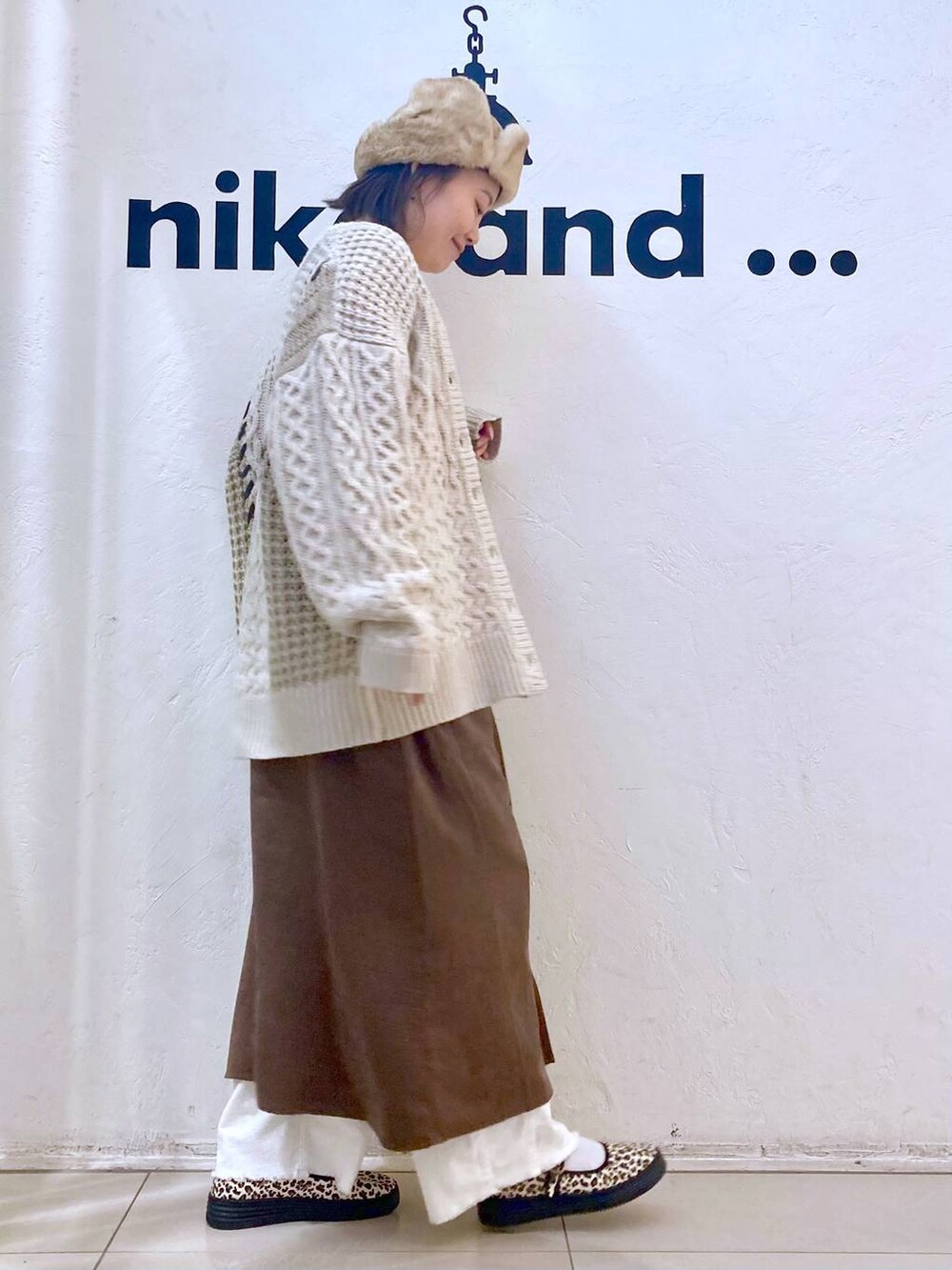 ホワイト系のその他パンツ、その他のスニーカー、ブラウン系のジャンパースカートを着用したレディースの冬コーディネートの5枚目の写真