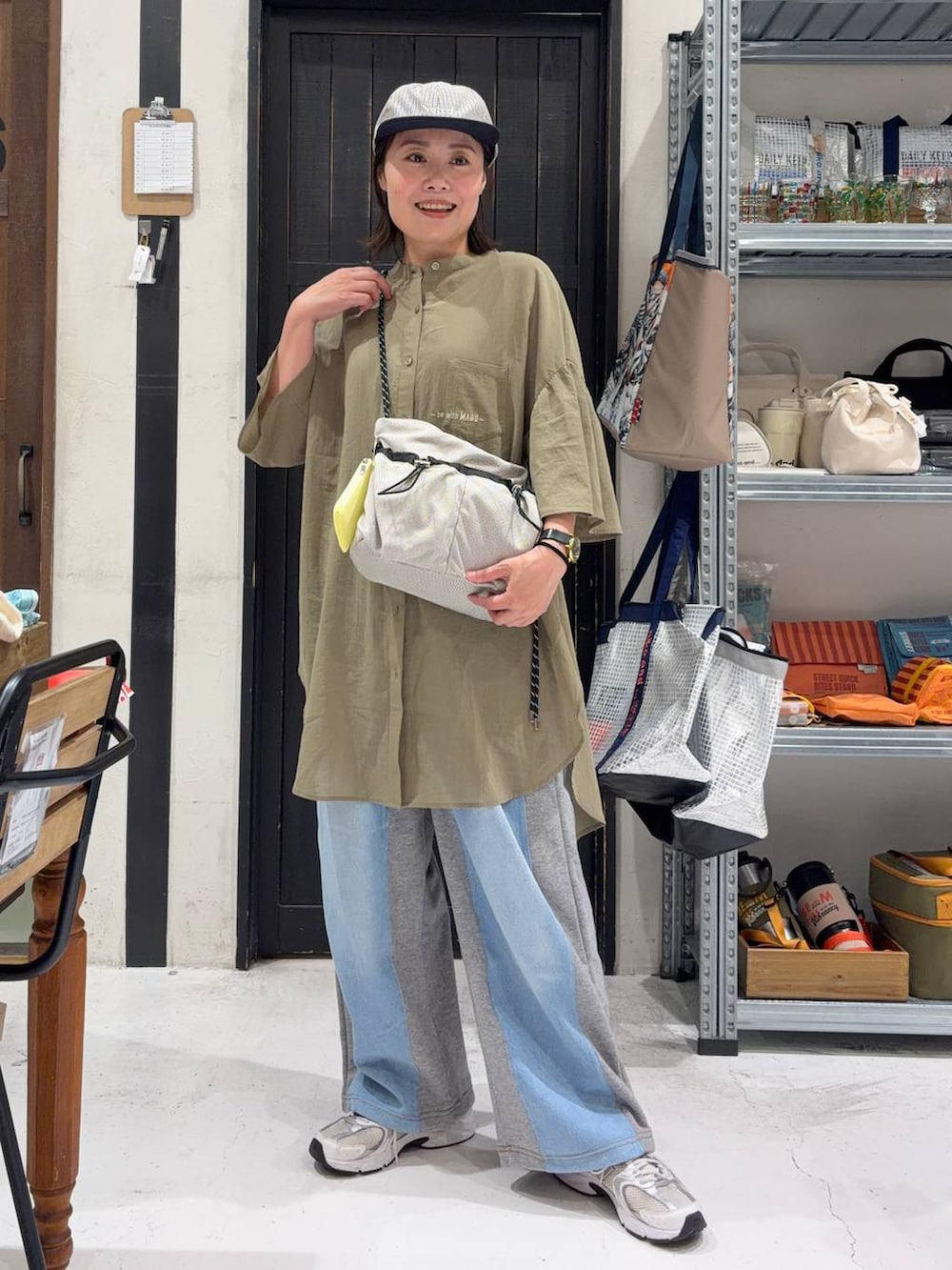 グレー系のデニムパンツ、ベージュ系のショルダーバッグを着用したレディースの夏コーディネートの2枚目の写真