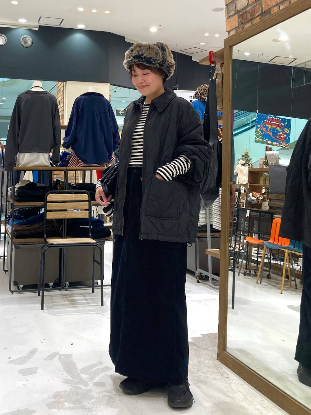 ブラック系のその他アウター、ホワイト系のニット/セーター、ブラック系のショルダーバッグを着用したレディースの冬コーディネートの4枚目の写真