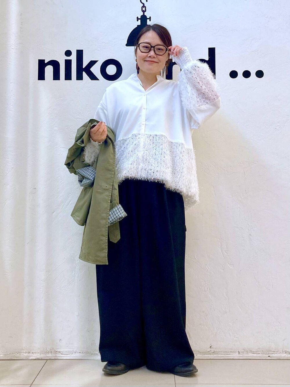ブラック系のその他パンツ、グリーン系のトレンチコート、ホワイト系のシャツ/ブラウスを着用したレディースの冬コーディネートの3枚目の写真