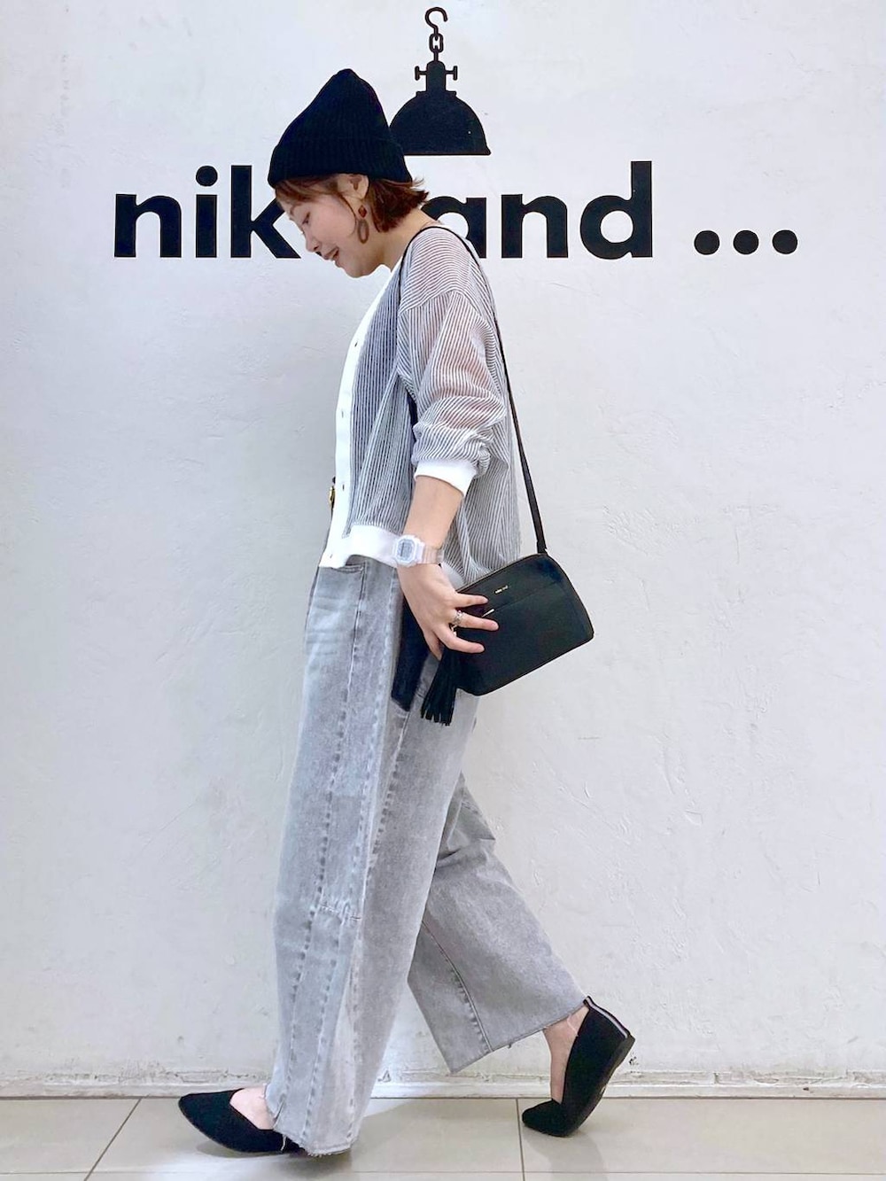 ホワイト系のカーディガン/ボレロ、グレー系のデニムパンツ、ブラック系のショルダーバッグを着用したレディースの春コーディネートの3枚目の写真