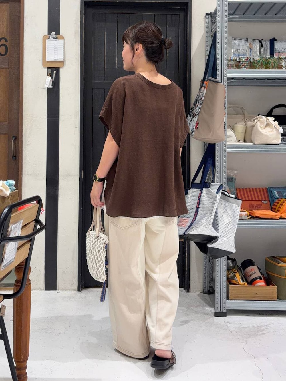 ベージュ系のデニムパンツ、ベージュ系のトートバッグ、ブラウン系のシャツ/ブラウスを着用したレディースの夏コーディネートの4枚目の写真
