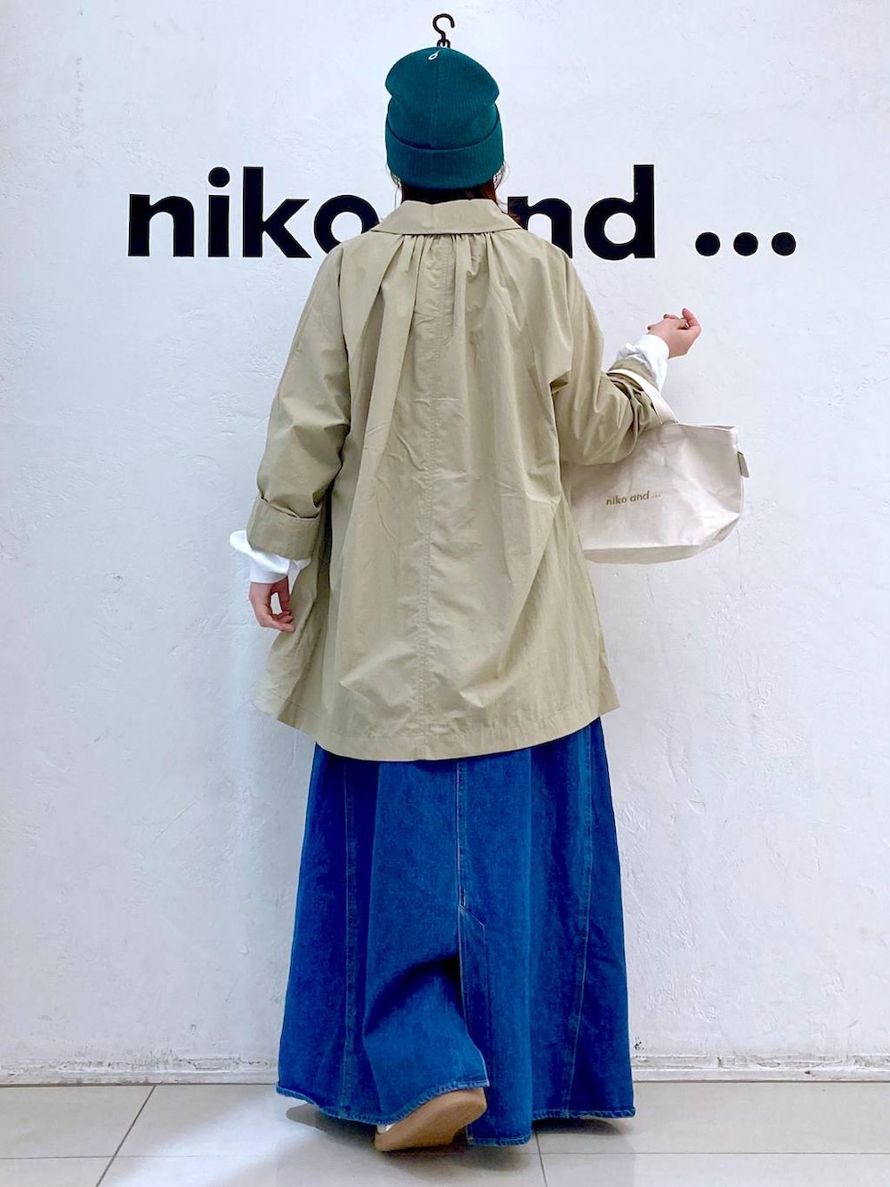 ホワイト系のスニーカー、ホワイト系のトートバッグ、シルバー系のピアス（両耳用）を着用したレディースの春コーディネートの4枚目の写真