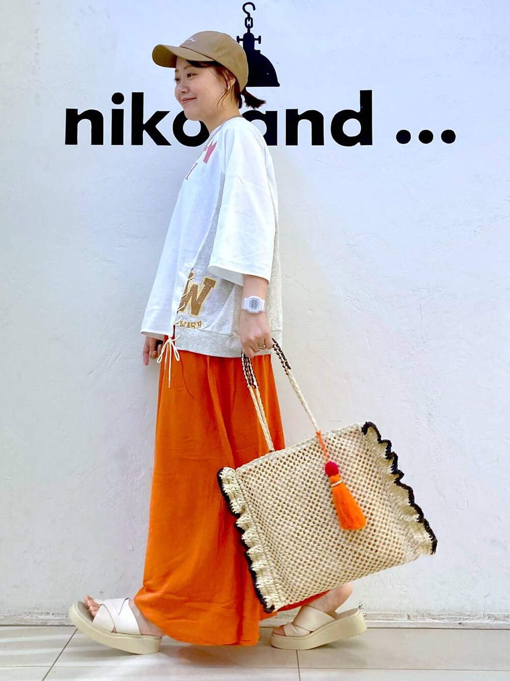 ベージュ系のサンダル、ベージュ系のトートバッグ、ホワイト系のデジタル腕時計を着用したレディースの夏コーディネートの3枚目の写真