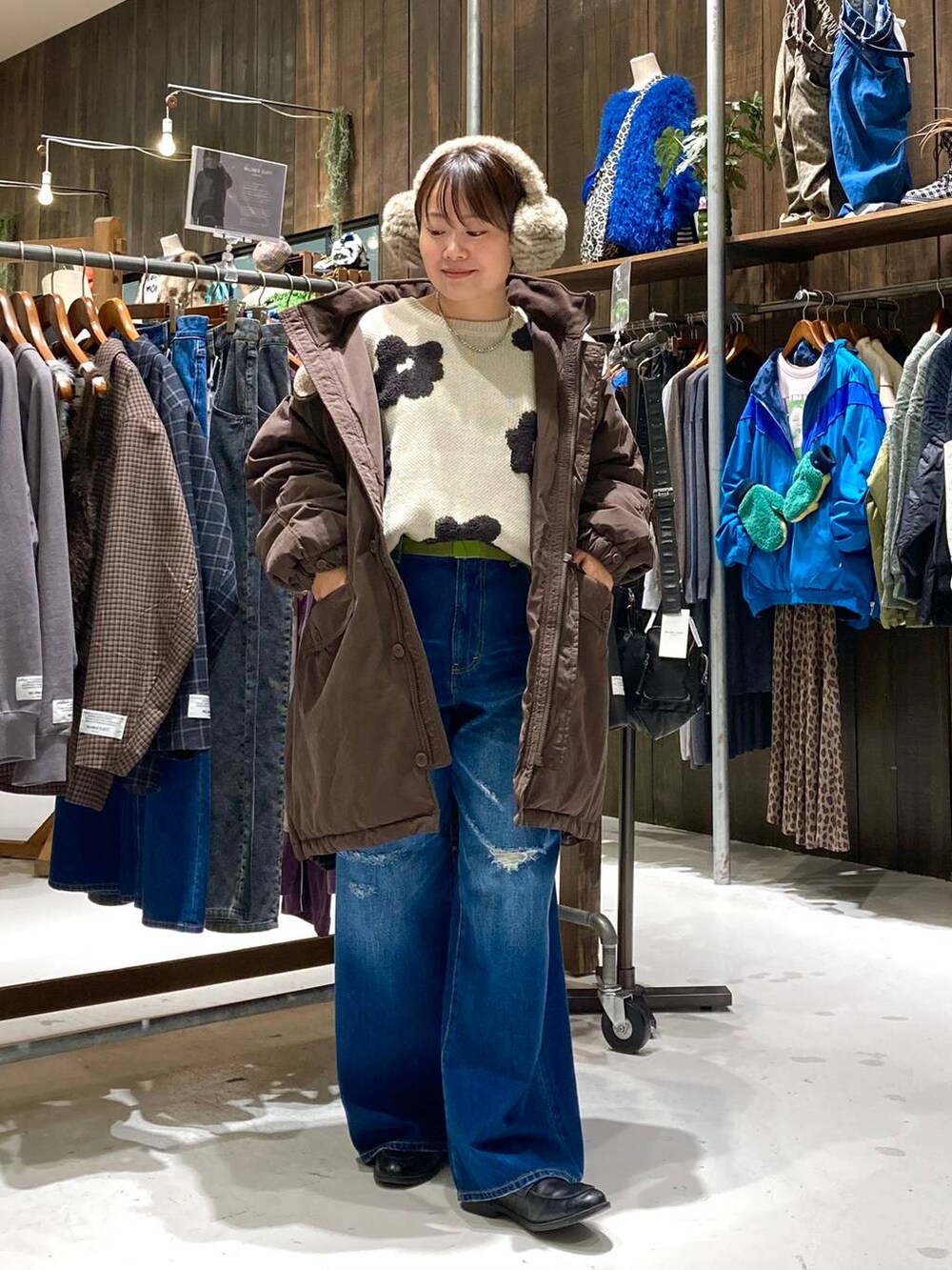ブラウン系のブルゾン、ブルー系のその他パンツ、ベージュ系のニット/セーターを着用したレディースの秋コーディネートの2枚目の写真