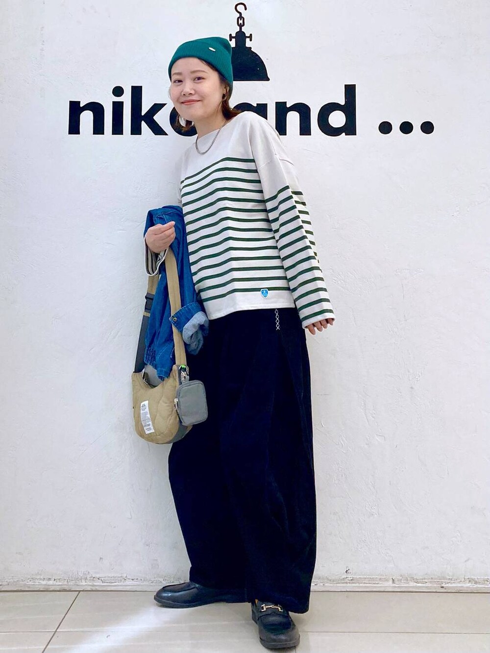 ブルー系のブルゾン、シルバー系のピアス（両耳用）、グレー系のブレスレットを着用したレディースの秋コーディネートの2枚目の写真