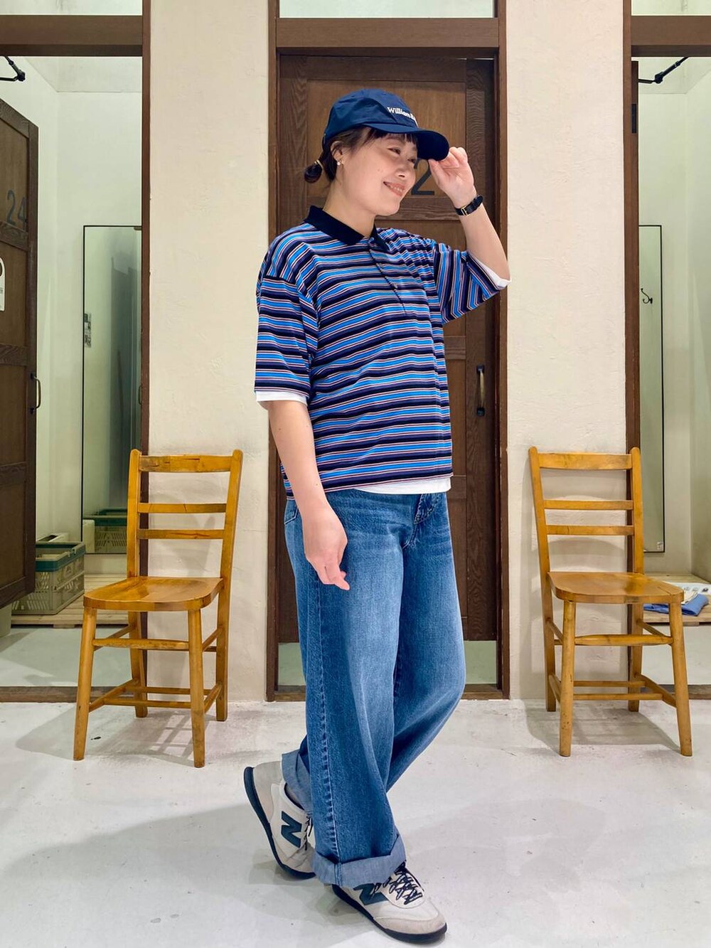 ホワイト系のスニーカー、ブルー系のTシャツ/カットソー、ブルー系のデニムパンツを着用したレディースの春コーディネートの5枚目の写真