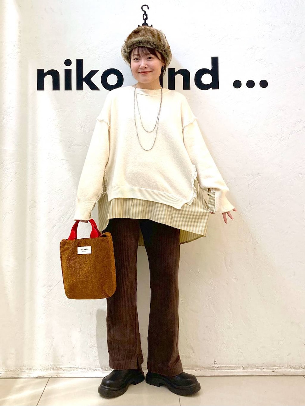 ブラウン系のその他パンツ、ブラック系のブーツ、レッド系のトートバッグを着用したレディースの冬コーディネートの3枚目の写真