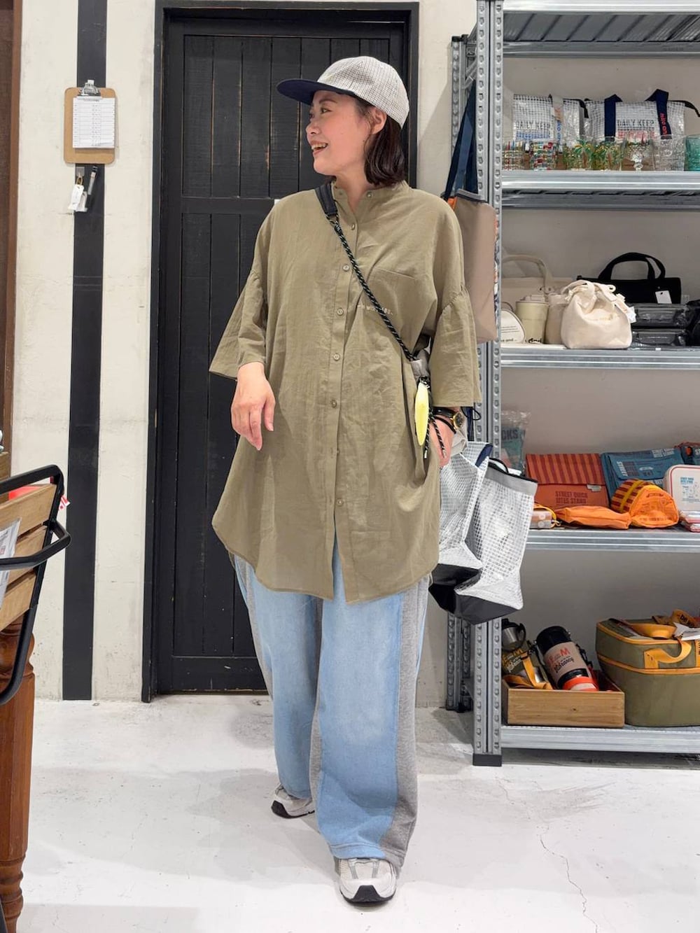 グレー系のデニムパンツ、ベージュ系のショルダーバッグを着用したレディースの夏コーディネートの6枚目の写真