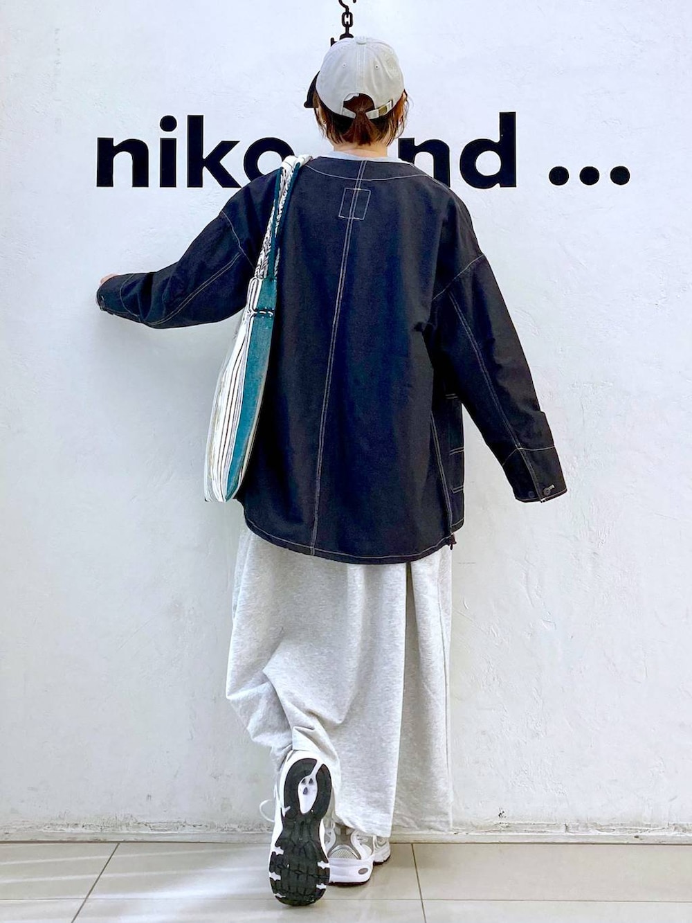 ベージュ系のワンピース、ブラック系のトートバッグ、その他のブルゾンを着用したレディースの春コーディネートの4枚目の写真