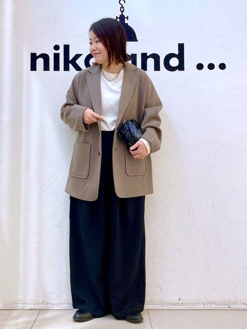 ブラウン系のテーラードジャケット、ブラック系のその他パンツ、ベージュ系のTシャツ/カットソーを着用したレディースの冬コーディネートの2枚目の写真