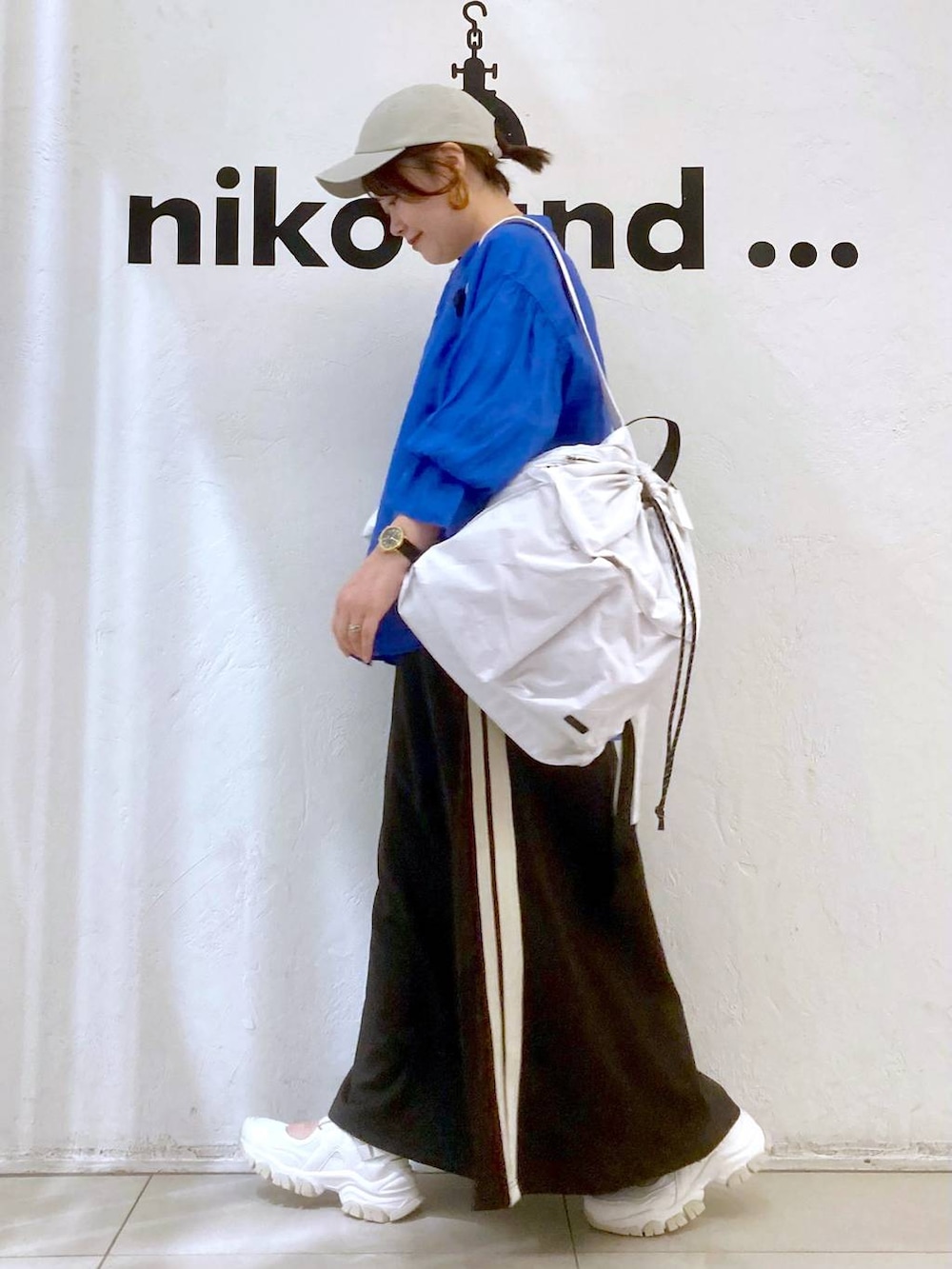 ベージュ系のバックパック/リュック、ホワイト系のTシャツ/カットソー、グレー系のスカートを着用したレディースの春コーディネートの5枚目の写真