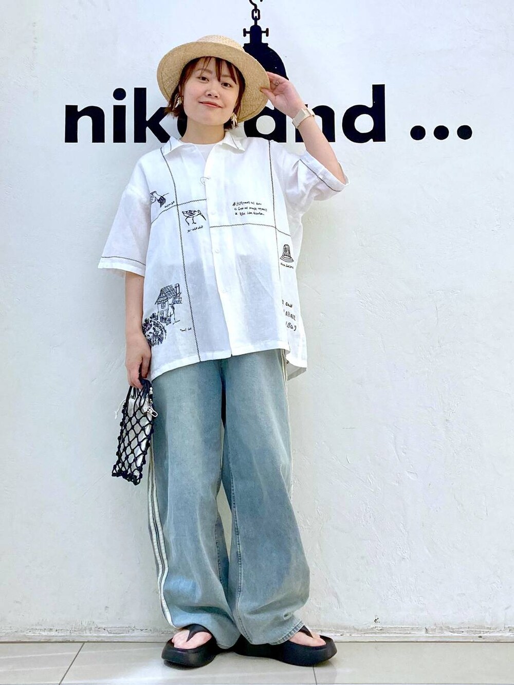 ブラック系のショルダーバッグ、ブラック系のサンダル、ホワイト系のTシャツ/カットソーを着用したレディースの春コーディネートの5枚目の写真