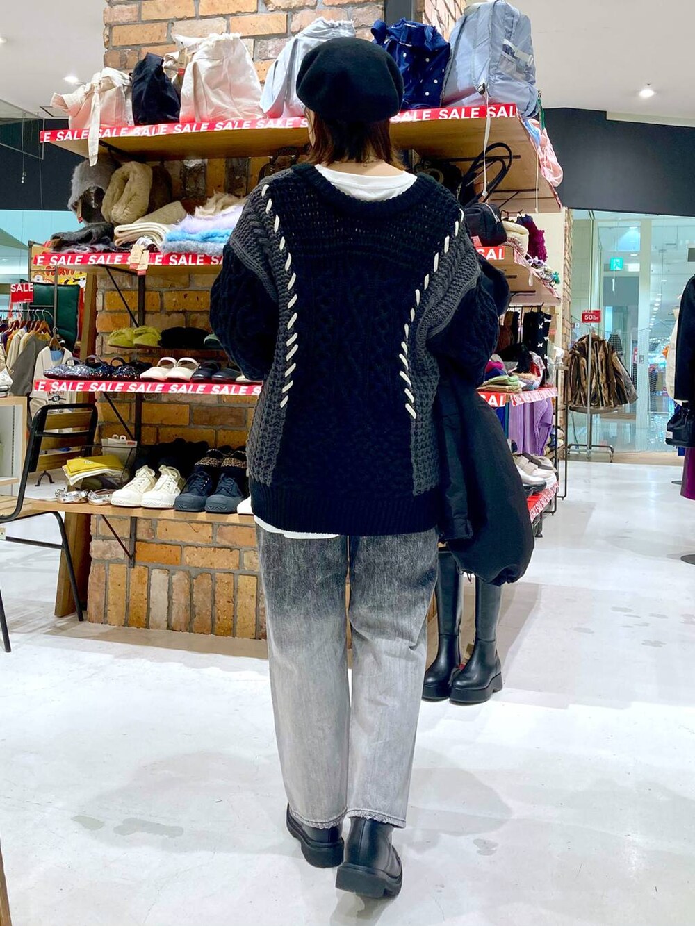 ブラック系のブルゾン、ブラック系のデニムパンツ、ホワイト系のTシャツ/カットソーを着用したレディースの冬コーディネートの5枚目の写真