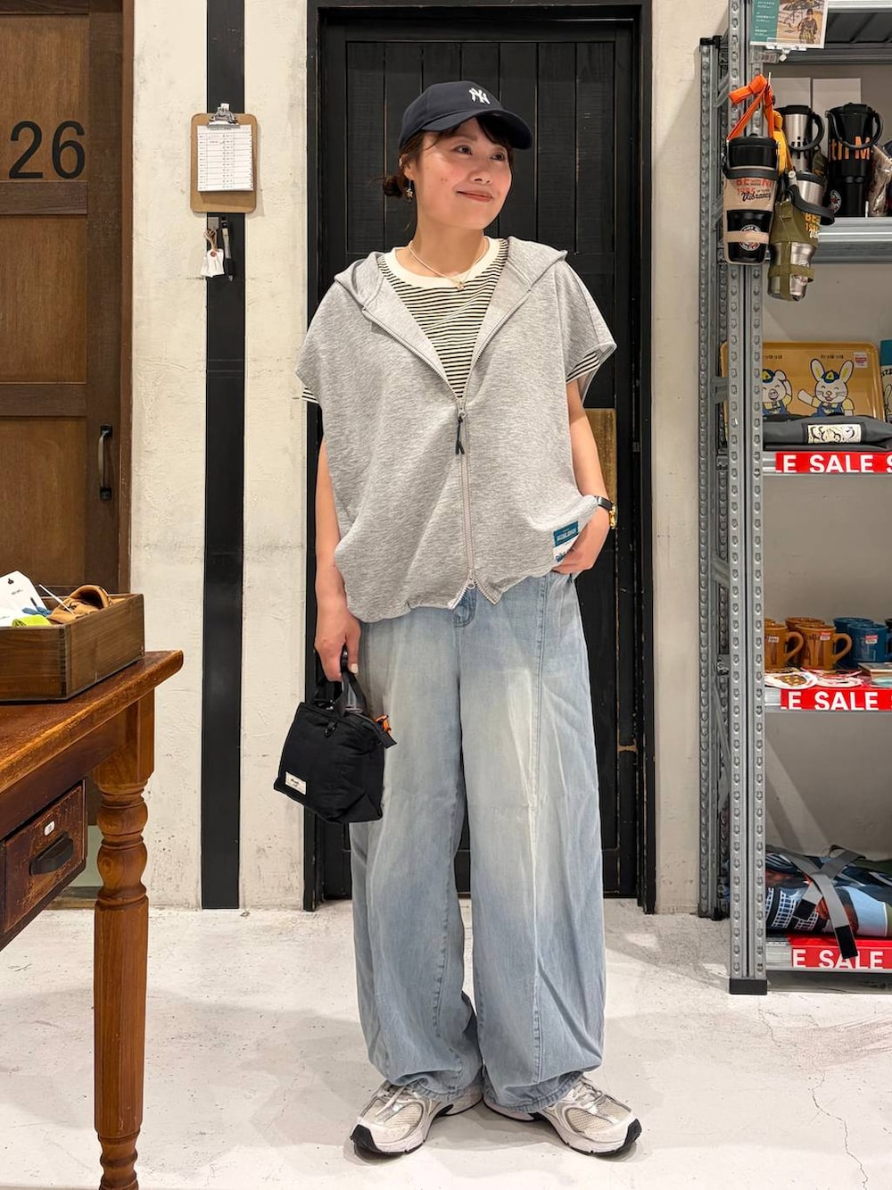 ブラック系のトートバッグ、その他のベスト、ベージュ系のTシャツ/カットソーを着用したレディースの夏コーディネートの2枚目の写真
