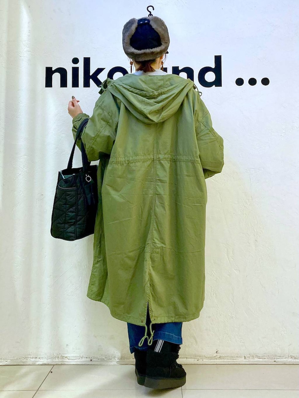 グリーン系のモッズコート、ブルー系のその他パンツ、ブラック系のトートバッグを着用したレディースの冬コーディネートの4枚目の写真