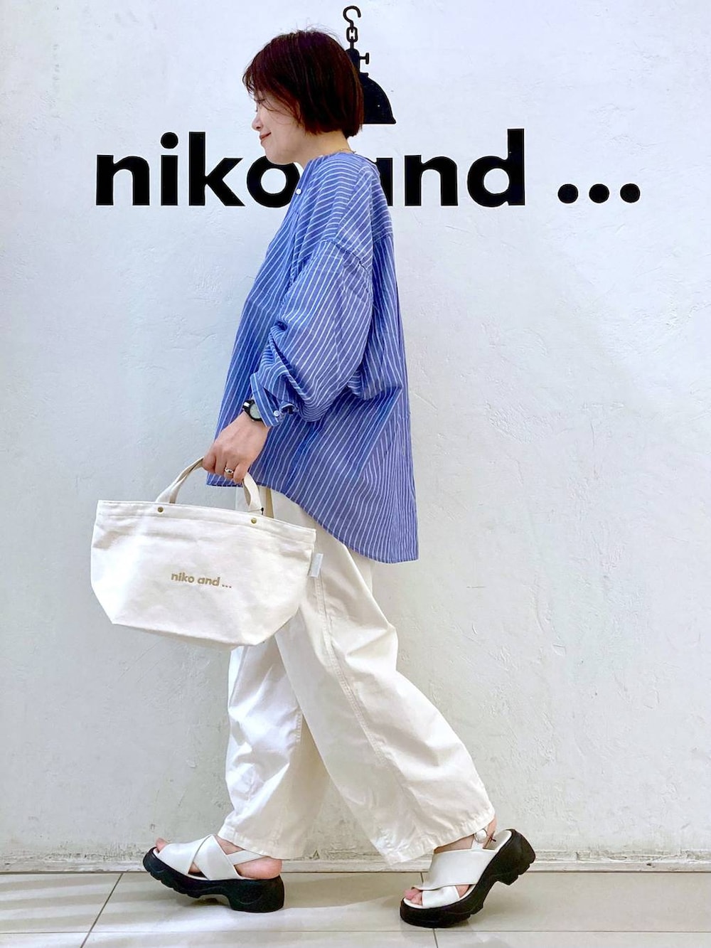 ホワイト系のサンダル、ベージュ系のTシャツ/カットソー、ホワイト系のトートバッグを着用したレディースの春コーディネートの5枚目の写真