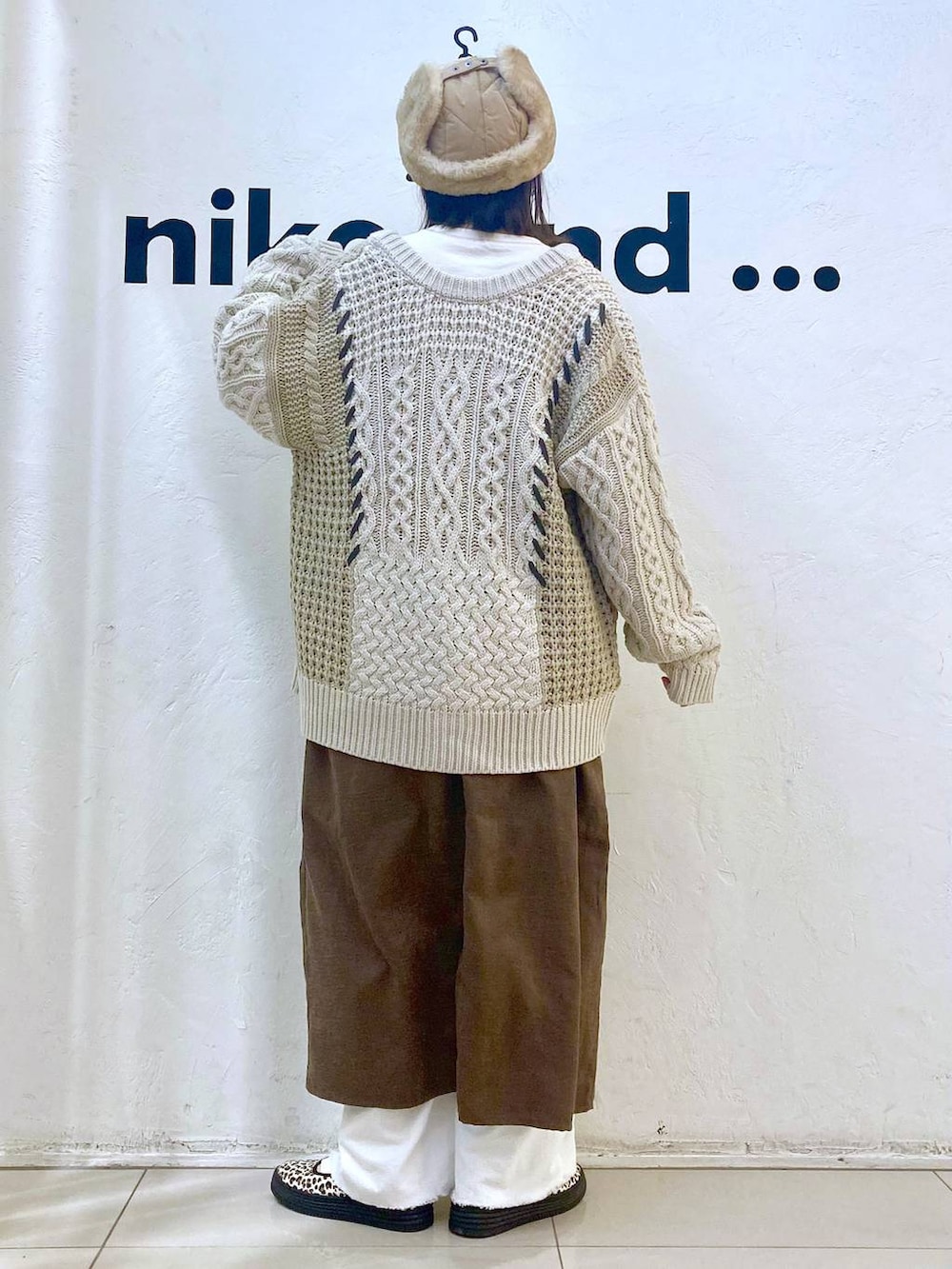 ホワイト系のその他パンツ、その他のスニーカー、ブラウン系のジャンパースカートを着用したレディースの冬コーディネートの4枚目の写真