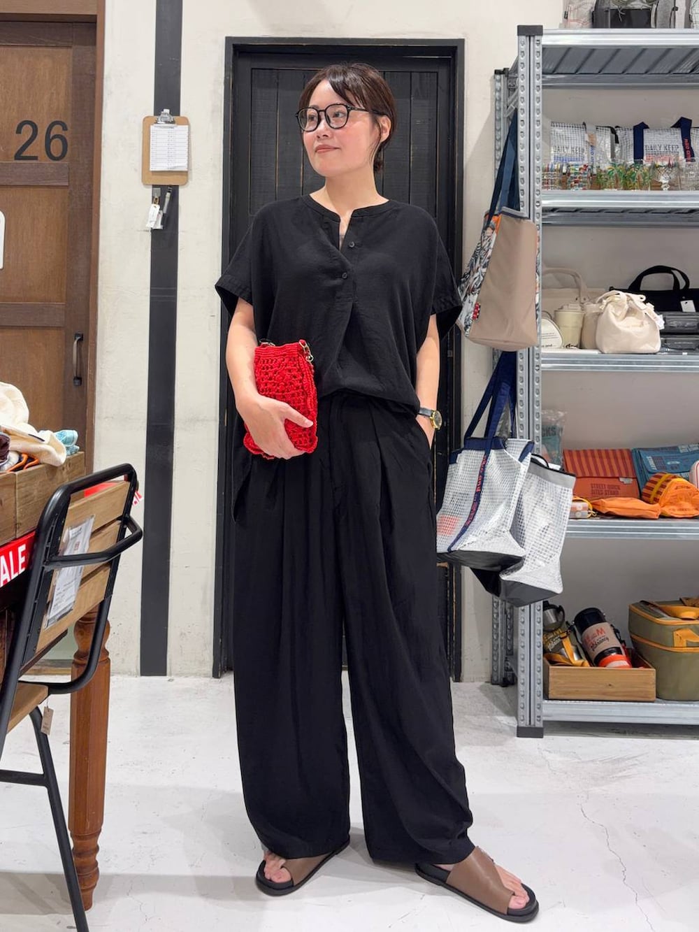 レッド系のショルダーバッグ、ブラック系のシャツ/ブラウス、ブラック系のその他パンツを着用したレディースの夏コーディネートの2枚目の写真