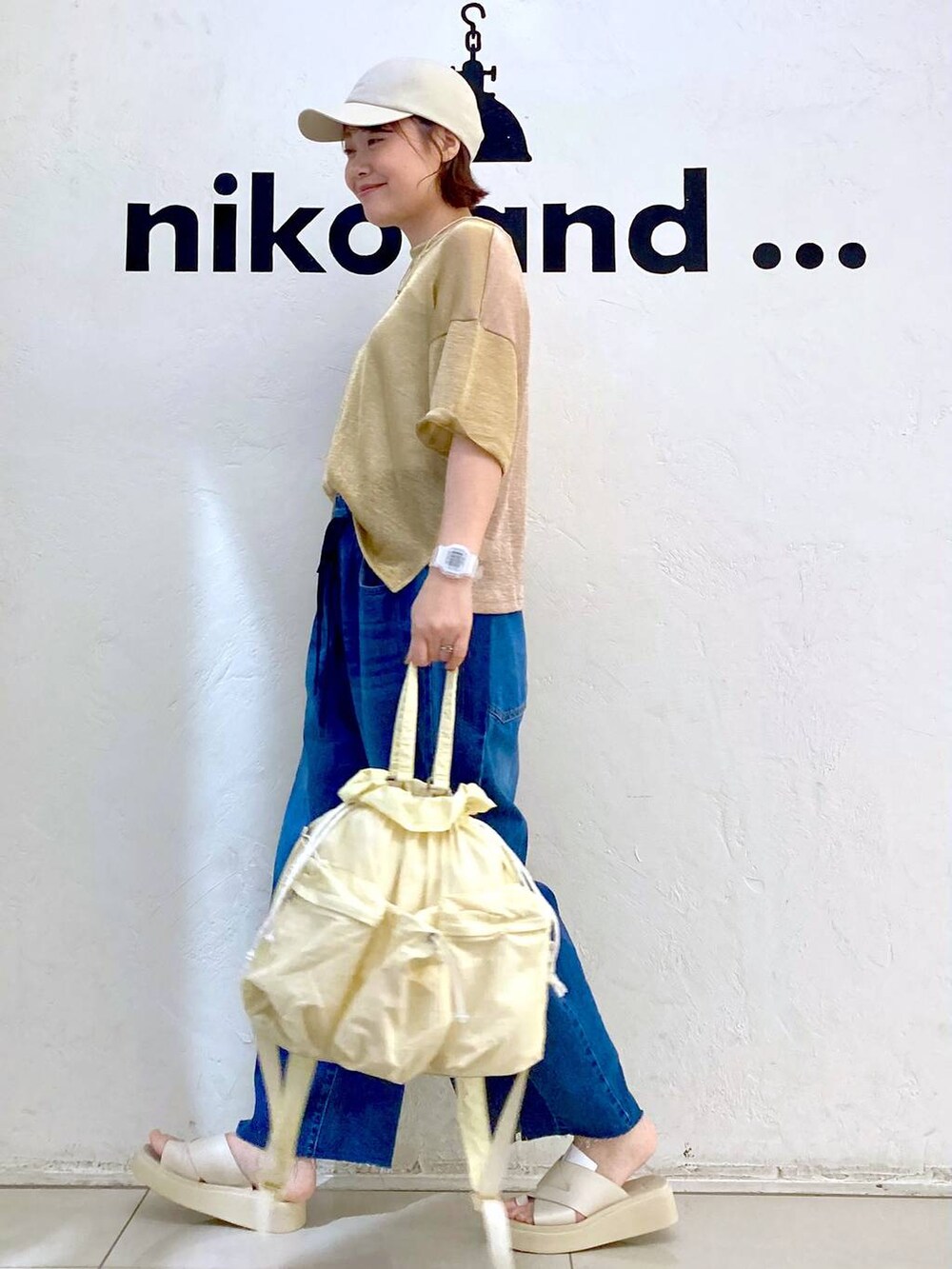 ベージュ系のサンダル、ブルー系のデニムパンツ、ベージュ系のタンクトップを着用したレディースの夏コーディネートの3枚目の写真