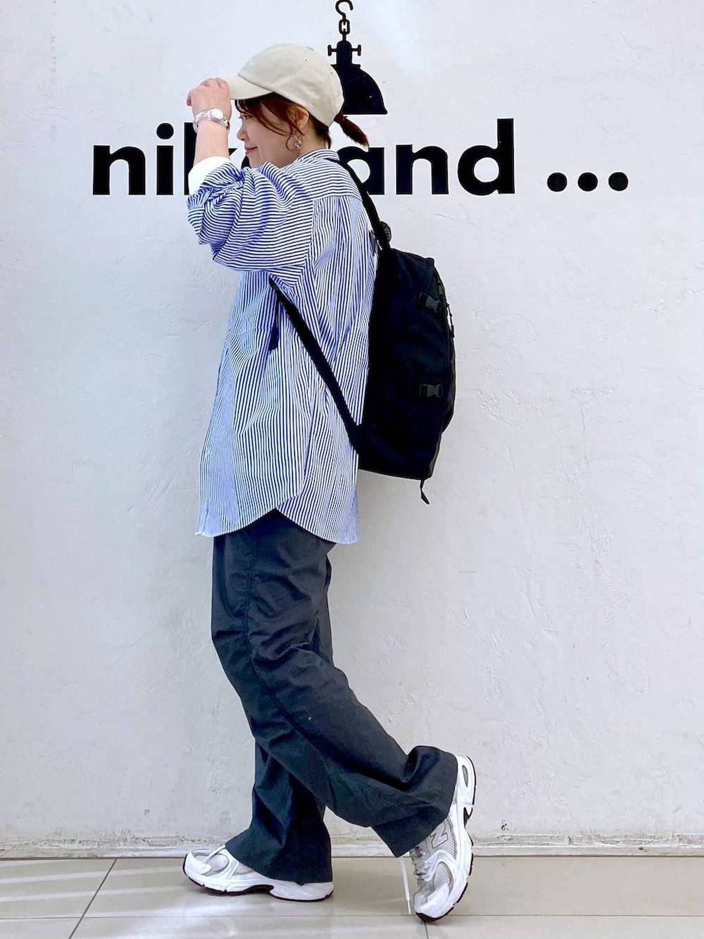 ホワイト系のTシャツ/カットソー、ブラック系のバックパック/リュック、グレー系のその他パンツを着用したレディースの春コーディネートの5枚目の写真