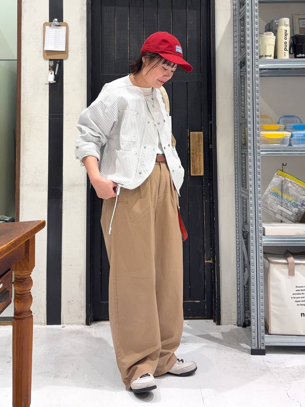 ホワイト系のトートバッグ、ベージュ系のカバーオール、ホワイト系のTシャツ/カットソーを着用したレディースの春コーディネートの5枚目の写真