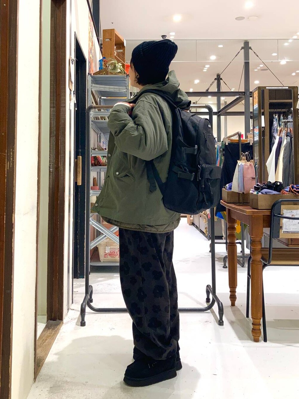 ブラック系のモカシン/デッキシューズ、ブラック系のバックパック/リュック、グレー系のその他パンツを着用したレディースの冬コーディネートの3枚目の写真