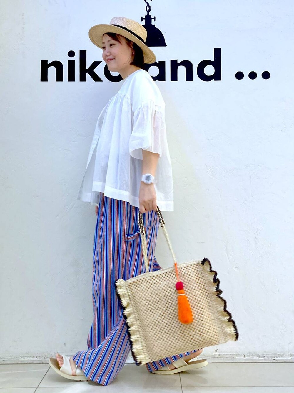 ベージュ系のトートバッグ、ホワイト系のTシャツ/カットソー、ブルー系のその他パンツを着用したレディースの夏コーディネートの3枚目の写真