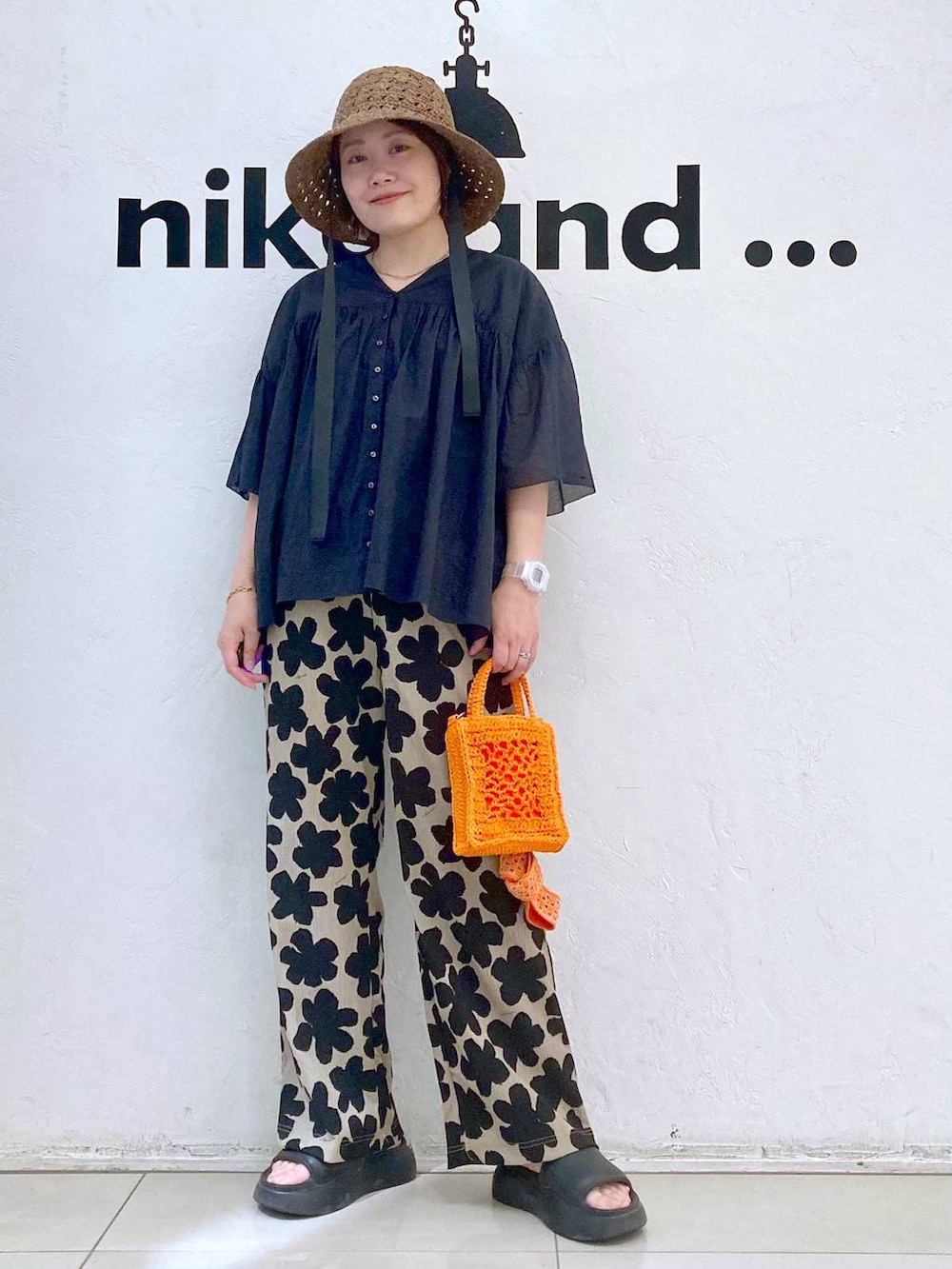 オレンジ系のショルダーバッグ、ブラック系のサンダル、その他のTシャツ/カットソーを着用したレディースの春コーディネートの2枚目の写真