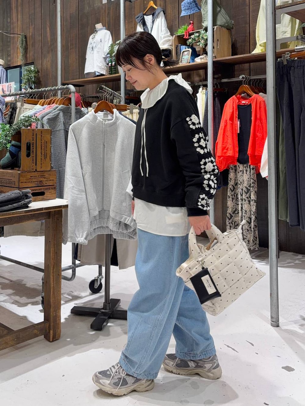 ブラック系のスウェット、ホワイト系のトートバッグ、ブルー系のその他パンツを着用したレディースの春コーディネートの2枚目の写真