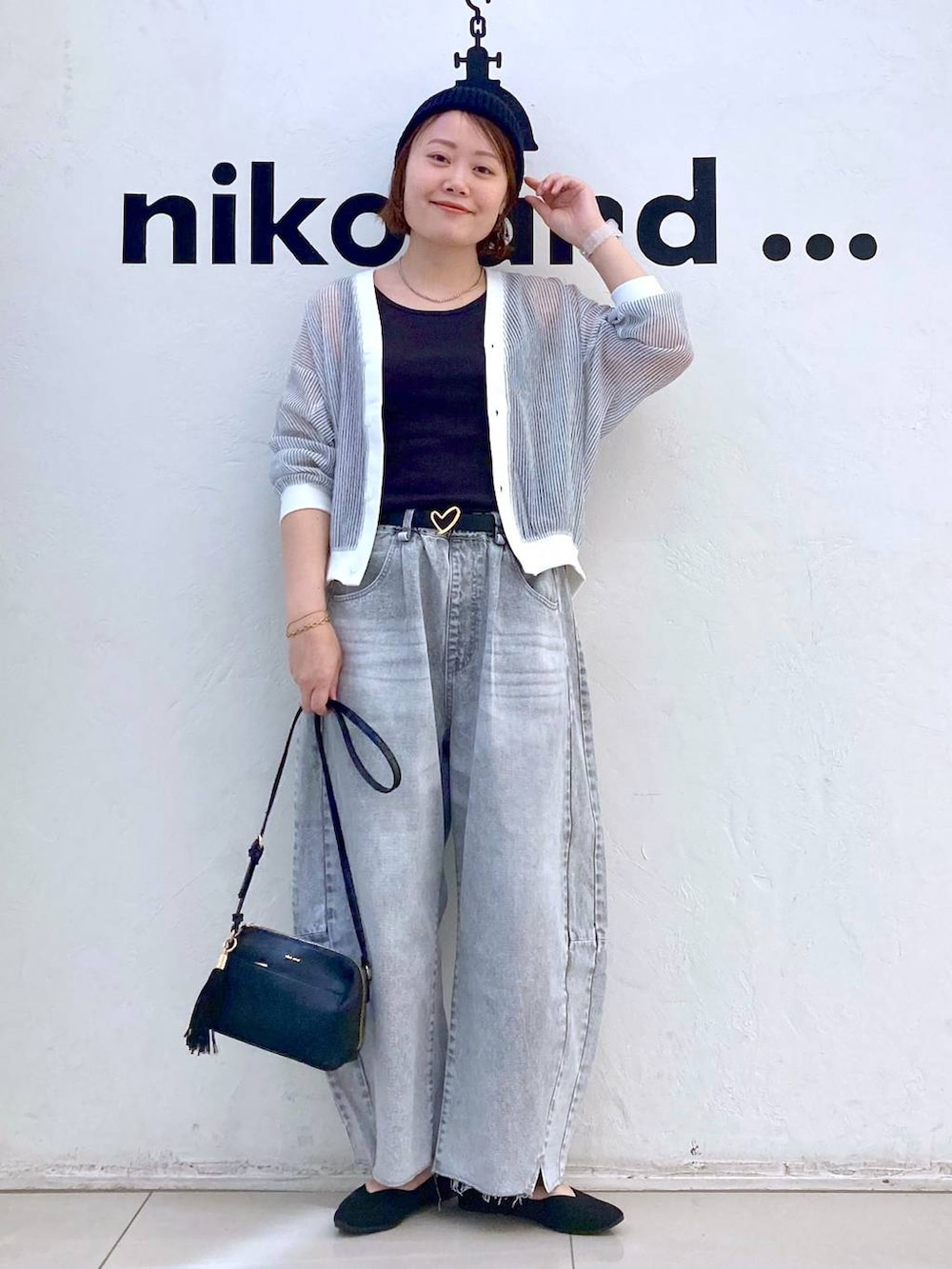 ホワイト系のカーディガン/ボレロ、グレー系のデニムパンツ、ブラック系のショルダーバッグを着用したレディースの春コーディネートの2枚目の写真